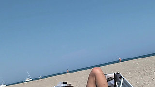 She masturbates her on the naturist beach in public with a voyeur who passes by
