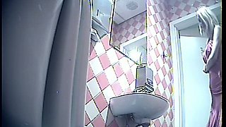 Stunning tall blonde lady in pink dress pissing in the toiletroom