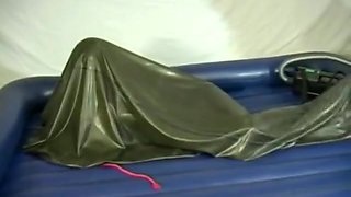 Woman struggling in a green latex bag