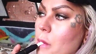 Blonde lady smokes an electronic cigarette on stair