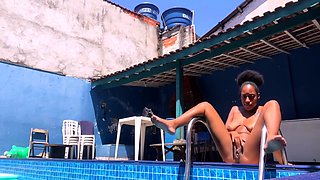 Busty black milf poses and plays with herself poolside