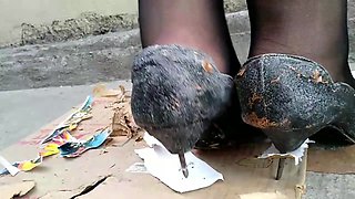 Girl stomping on picture in black metal high heels
