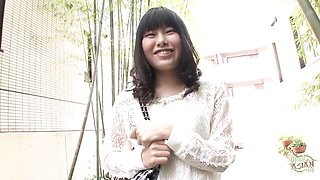 Asian nude on brown leather couch gives oral still holding notebook and blue pen